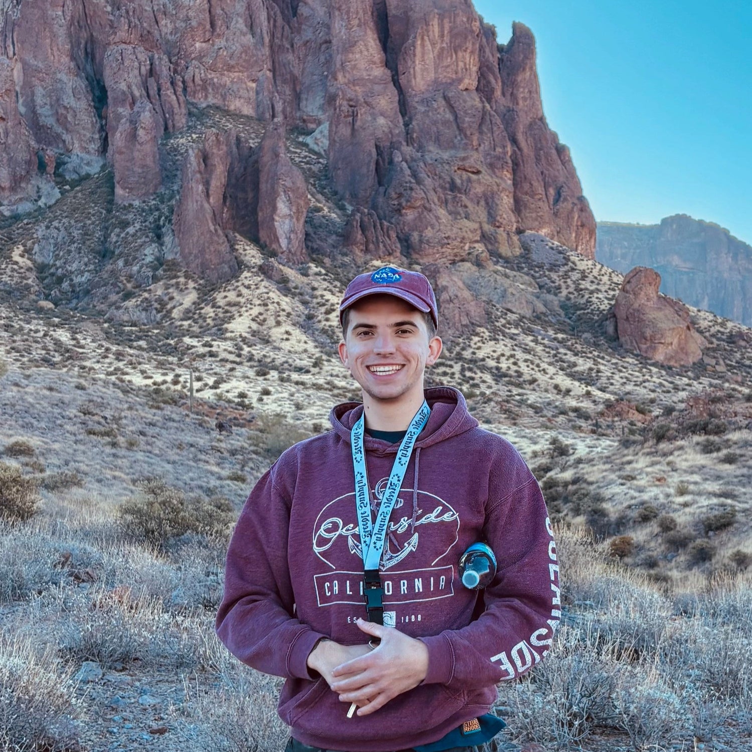 Person standing in a desert landscape with mountains in the background